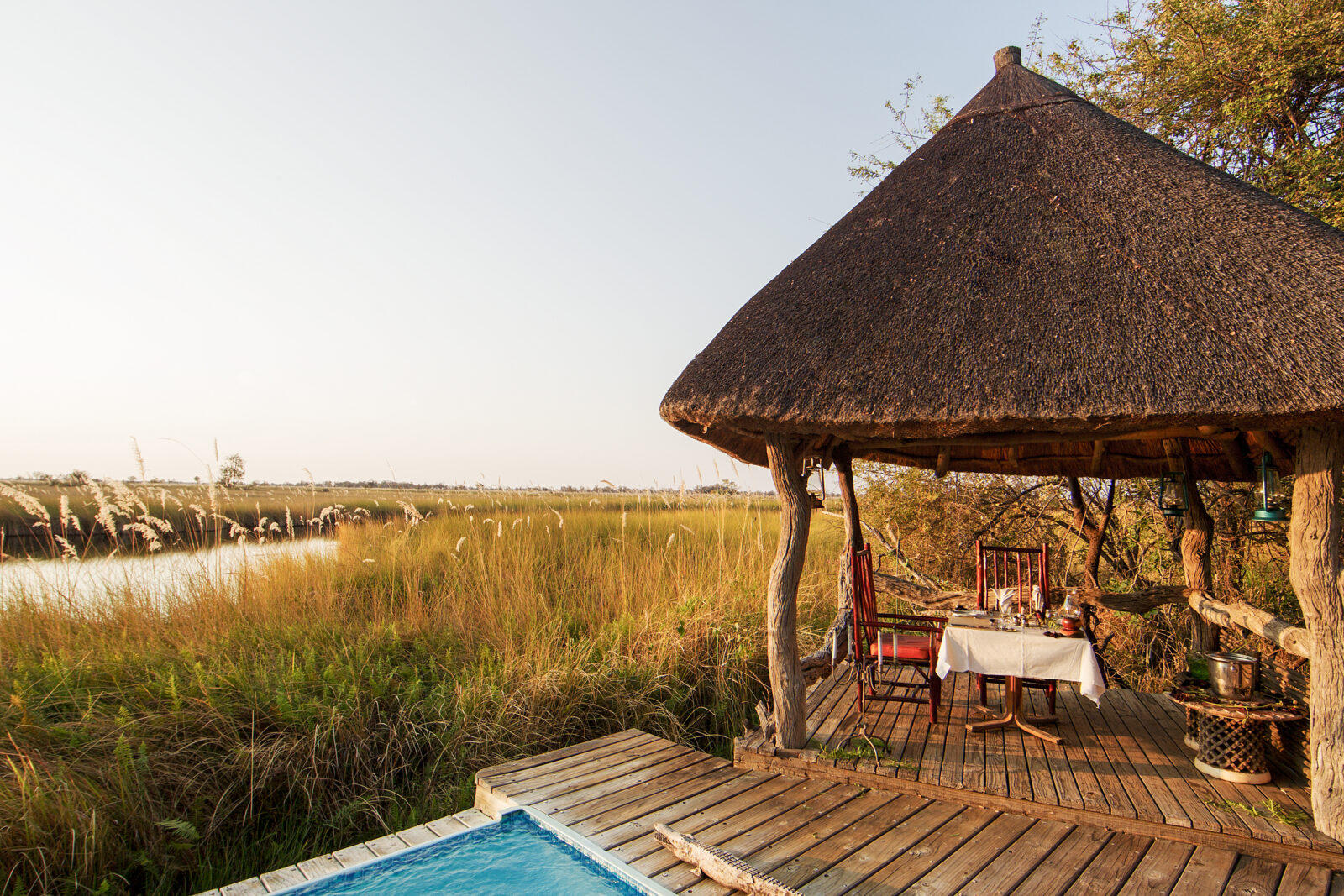 The plunge pool and shaded dining deck looking across the floodplain at Camp Xakanaxa, Moremi Game Reserve, Botswana