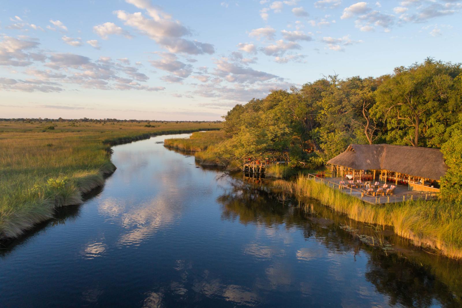 Aerial view of Camp Xakanaxa beside the Khwai channel and the Moremi floodplains, Okavango Delta, Botswana