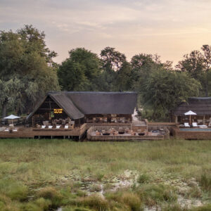 Aerial view of the tents and main area of Sable Alley beside a lily-covered lagoon in the Khwai Private Reserve, Botswana