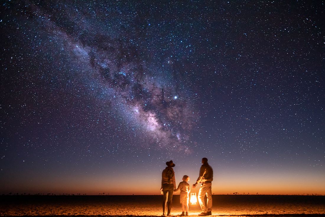 The Milky Way above the salt pans beside a lantern at Camp Kalahari, Makgadikgadi, Botswana