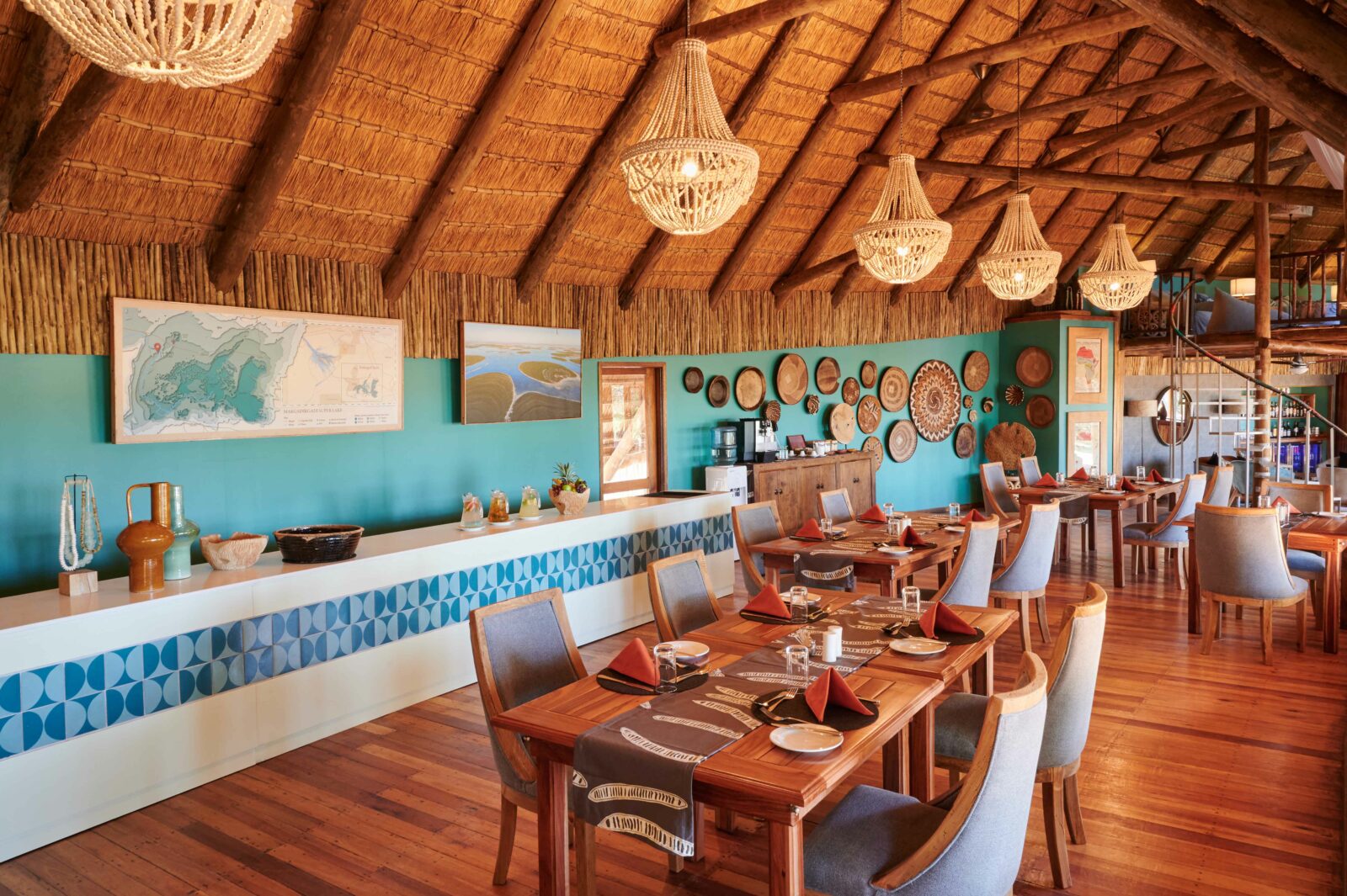 The thatched dining room with painted panels and laid tables at Leroo La Tau, Makgadikgadi, Botswana