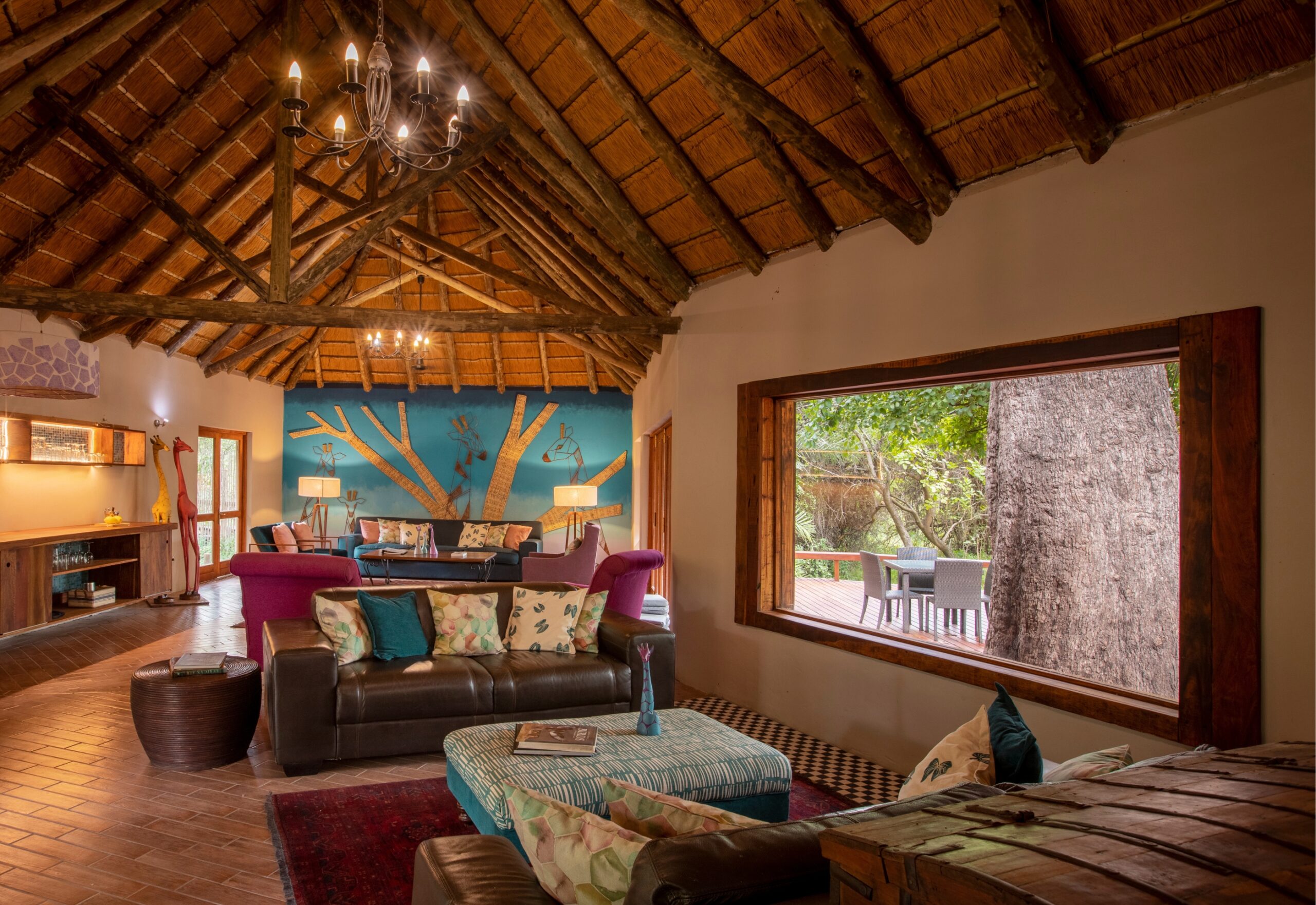 Lounge with thatched ceiling and open view to the gardens at Thamo Telele