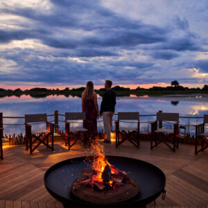 The overwater fire deck at Xugana Island Lodge at dusk, looking across Xugana Lagoon in the Okavango Delta, Botswana