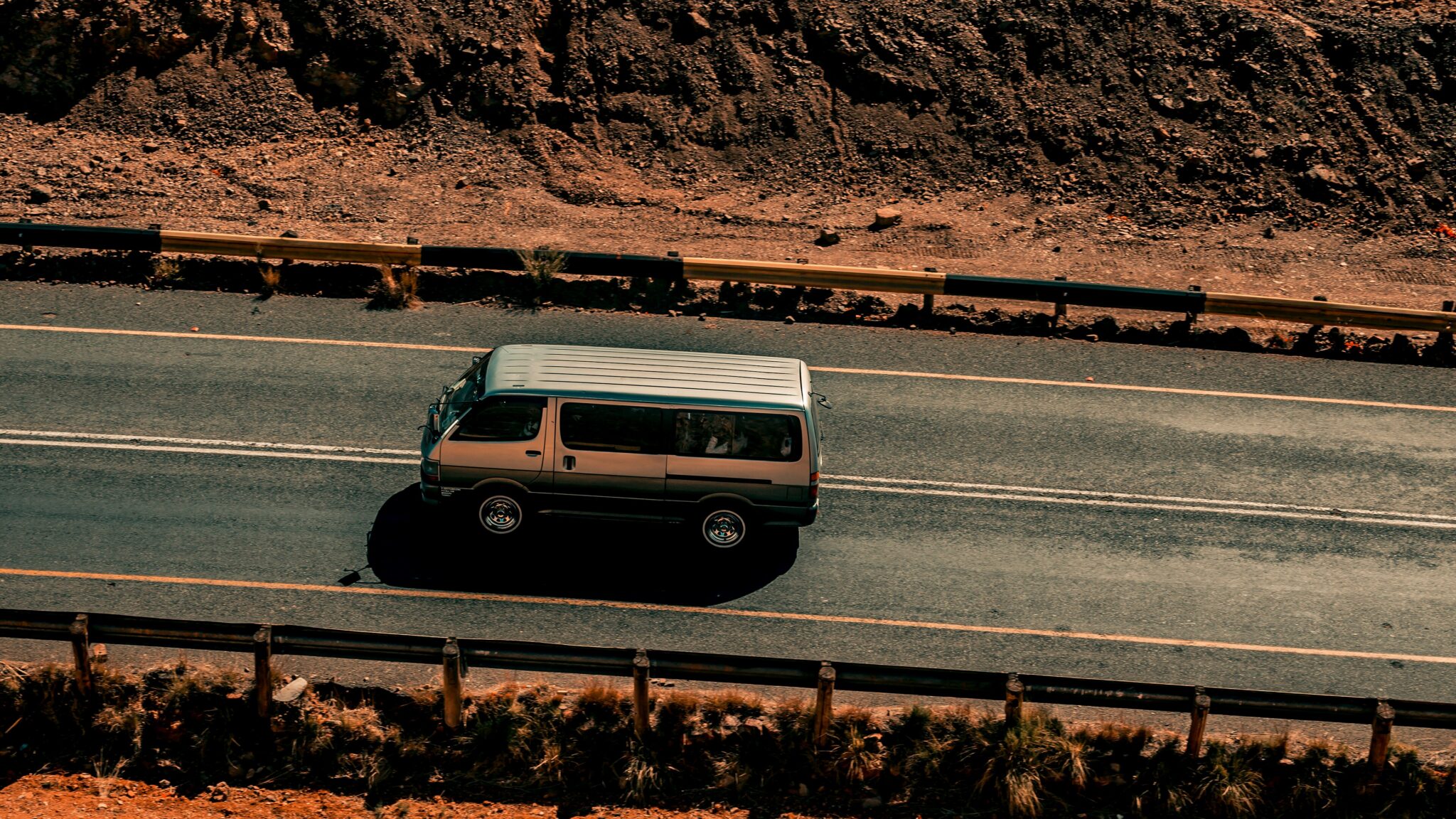 A minibus on the tar road at the outskirts of Kanye in south-east Botswana, where the road is cut through rock