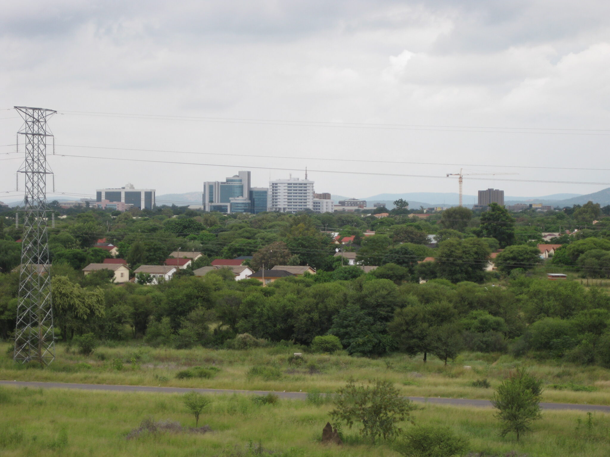 The skyline of Gaborone, Botswana, seen across low green bush
