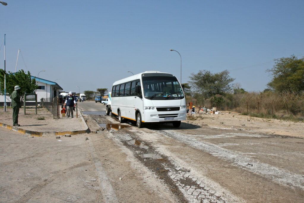 A bus and travellers at the Zambia to Botswana border crossing