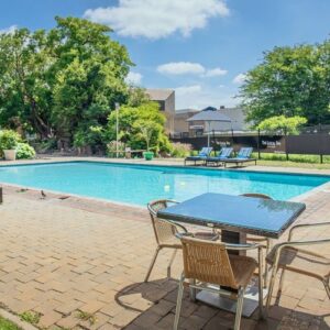 The swimming pool, paved terrace and mature garden trees at Cresta Lodge Gaborone, Botswana