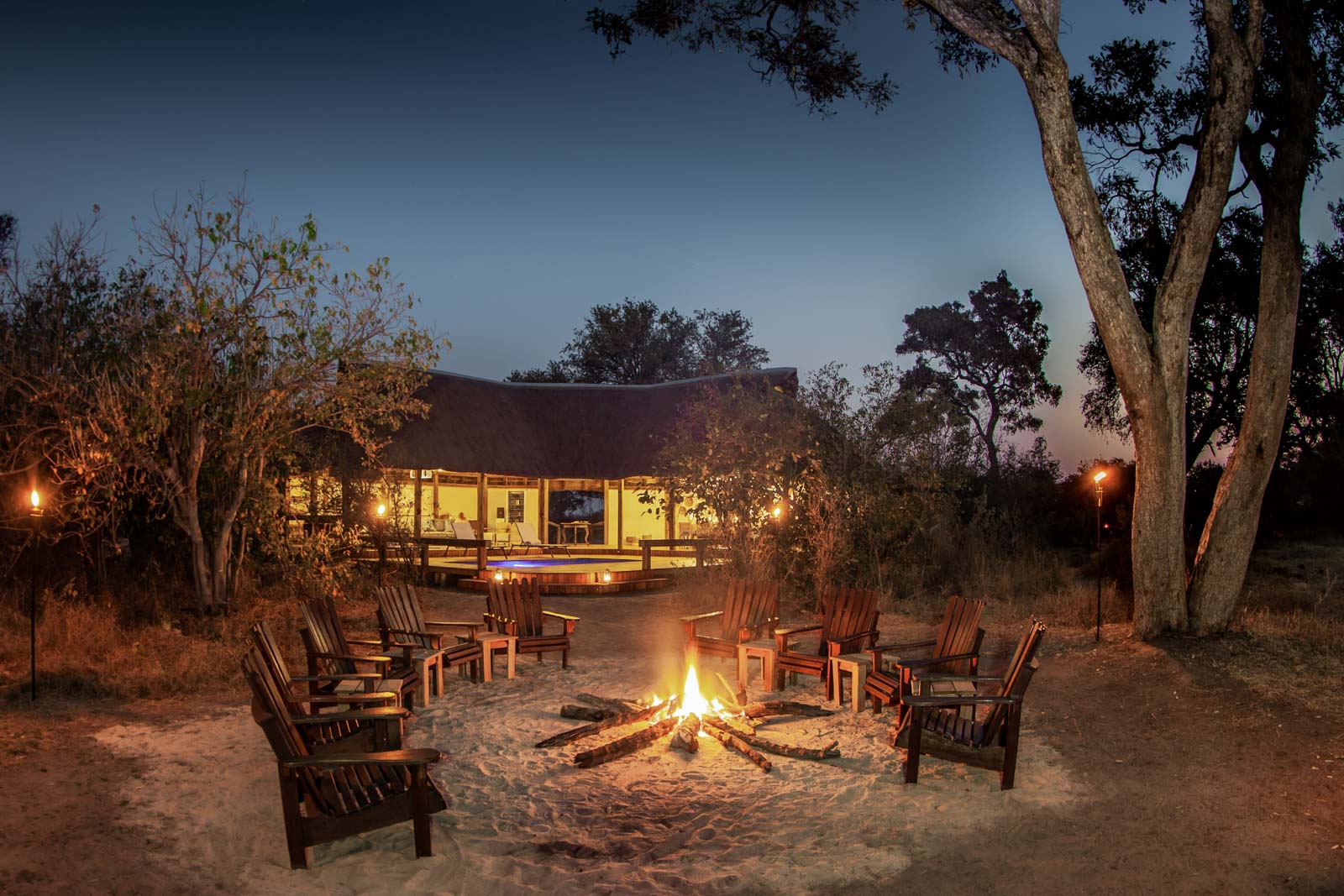 Camp chairs around a fire at the private Splash Enclave, Kwara Concession, Okavango Delta, Botswana