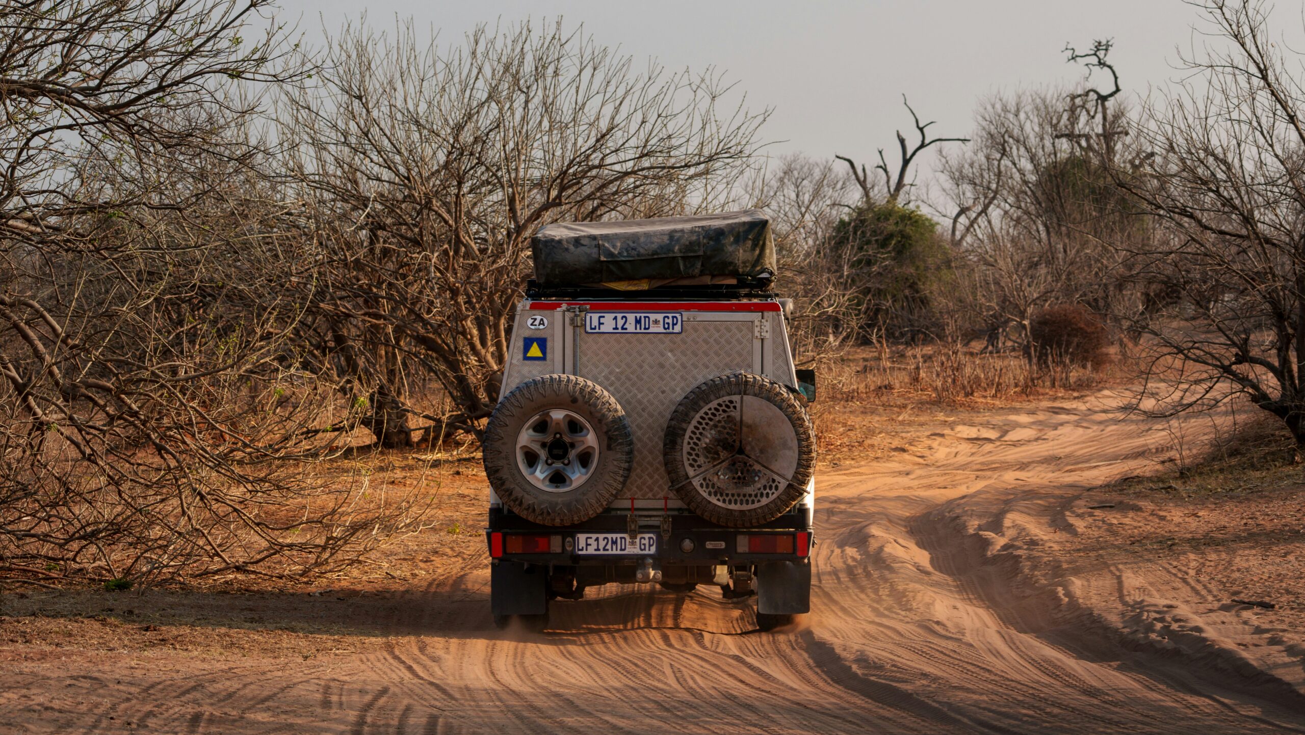 Deep sand driving — a four-wheel-drive vehicle travelling on a dusty Botswana track